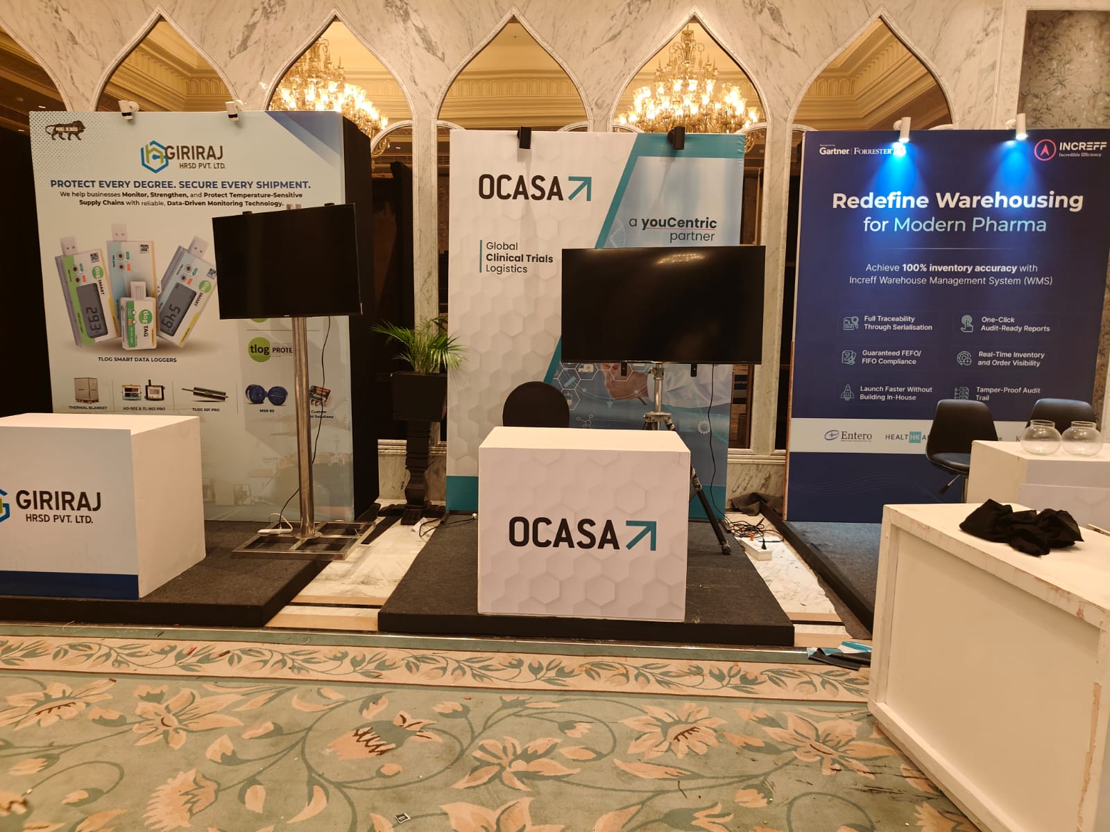 branded exhibition stall with backlit wall, counters and visitors